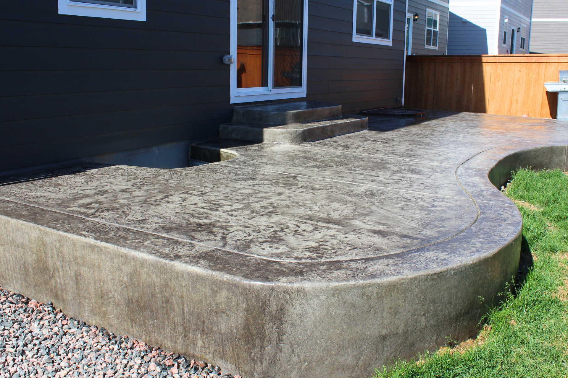 A slippery back patio with curved edges and stamped concrete in Joliet, IL.