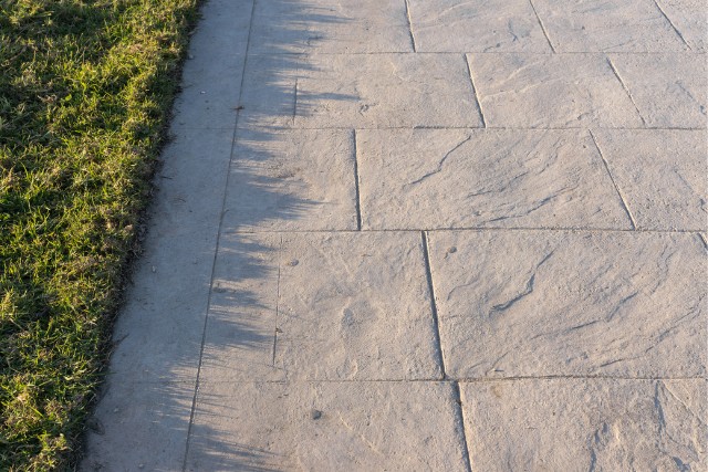 Stamped concrete walkway with a light gray slate stone pattern.