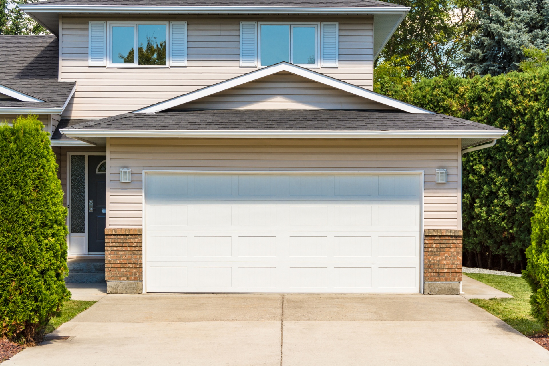 A well-maintained concrete driveway leading to a two-car garage.