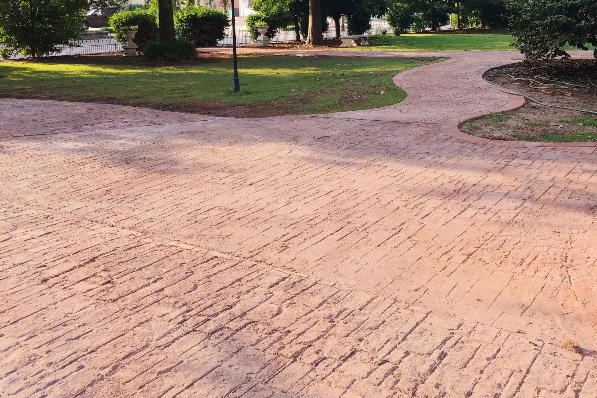 A red-tinted resurfaced stamped concrete driveway and walkway.