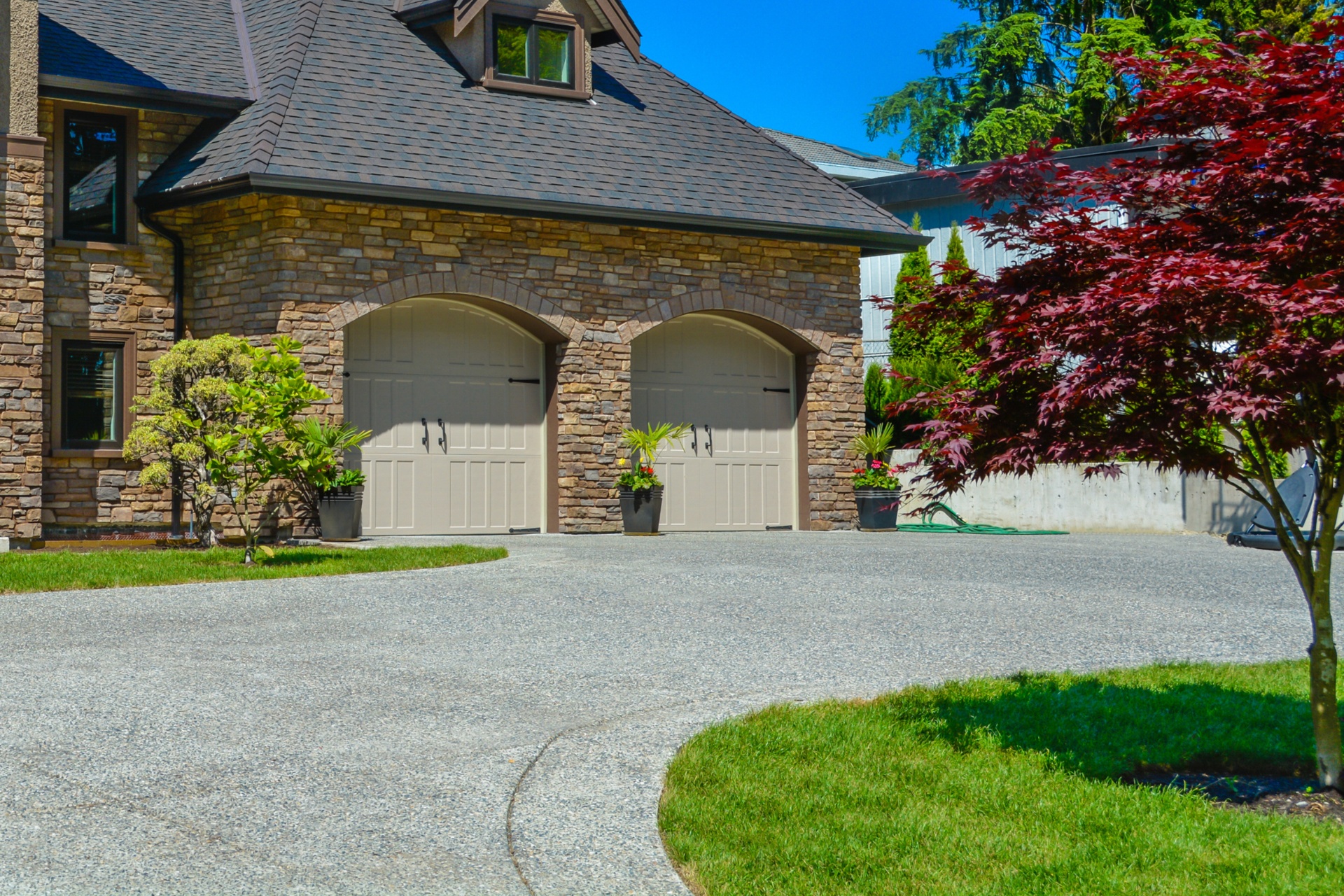 A sealed concrete driveway leading to the garage of a luxury home.