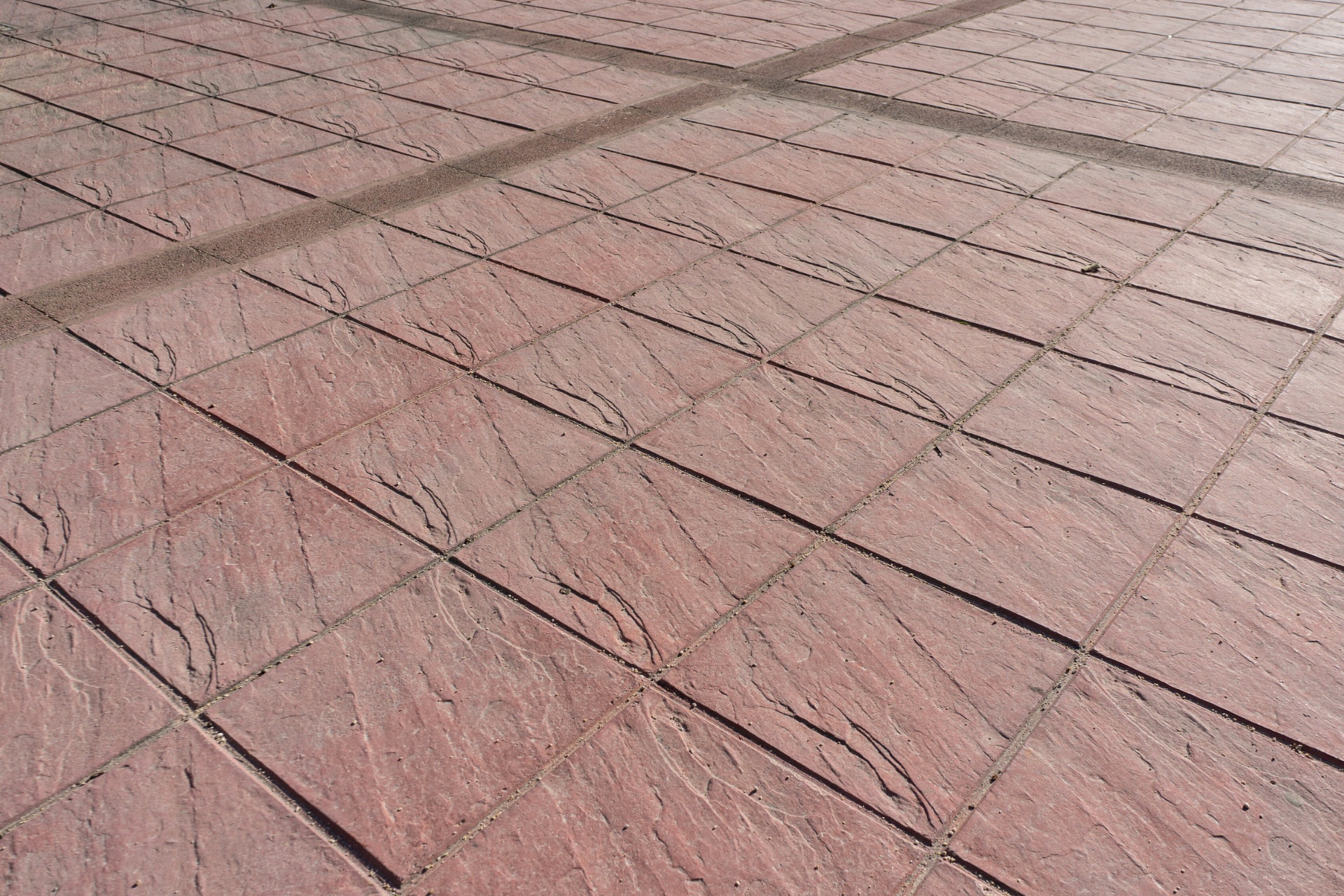 A large stamped concrete patio with red-tinted concrete squares.